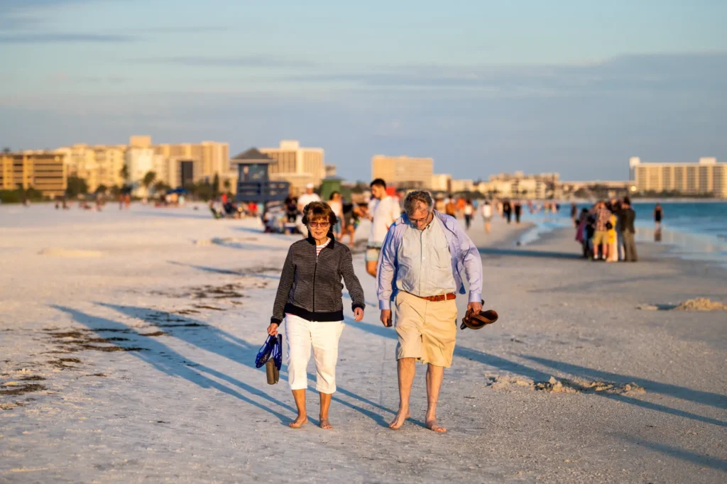 A couple walking on beach in Sarasota, FL. after recovering from shoulder replacement
