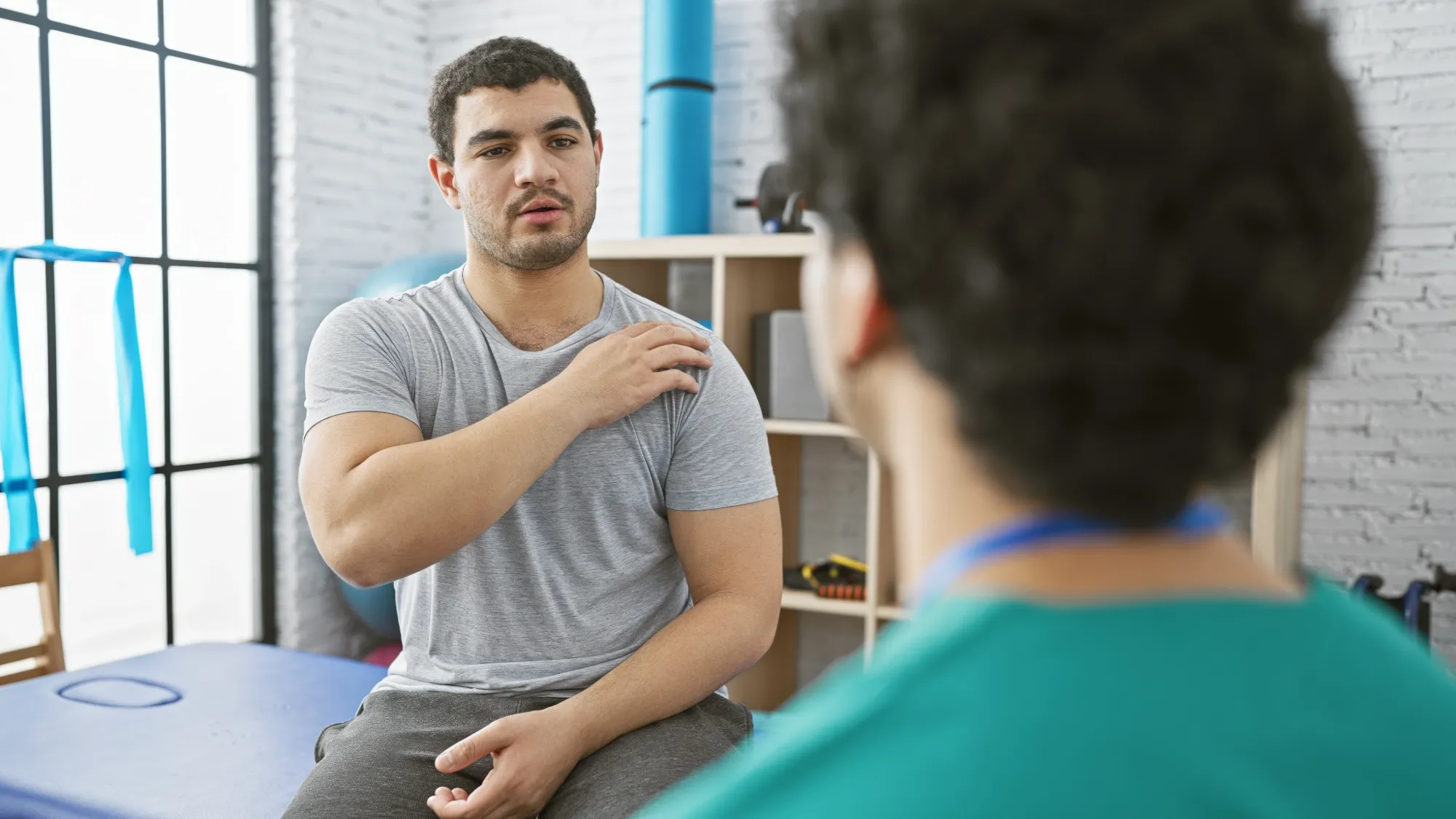 patient discussing his shoulder pain at night with his doctor.