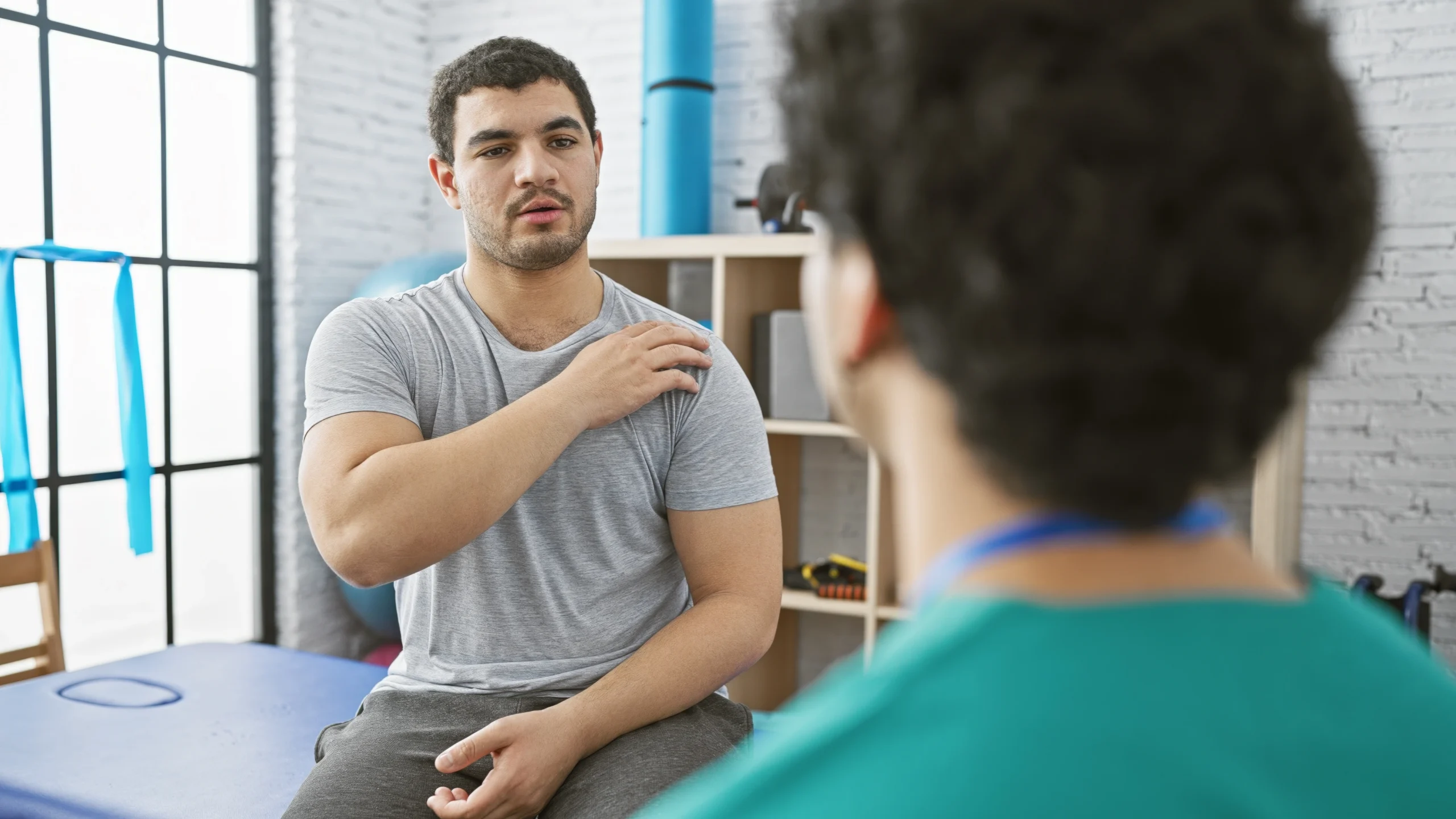 patient discussing his shoulder pain at night with his doctor.