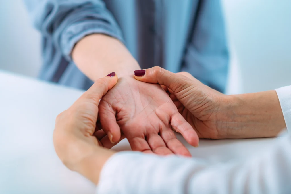 Doctor examining a senior patient with carpal tunnel syndrome.